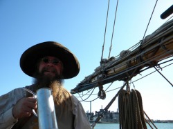 pirate reinactor raises a tankard starboard of Pride's boom